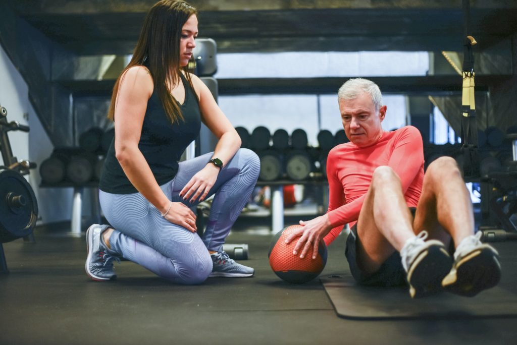 Over 50 male working with a personal trainer.