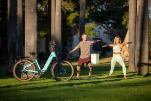 A couple exercising in a park standing next to a e-bike for arthritic knees.