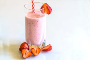 Strawberry smoothie in a glass with a straw - Night Time Smoothie For Weight Loss