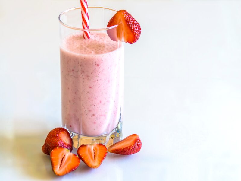 Strawberry smoothie in a glass with a straw