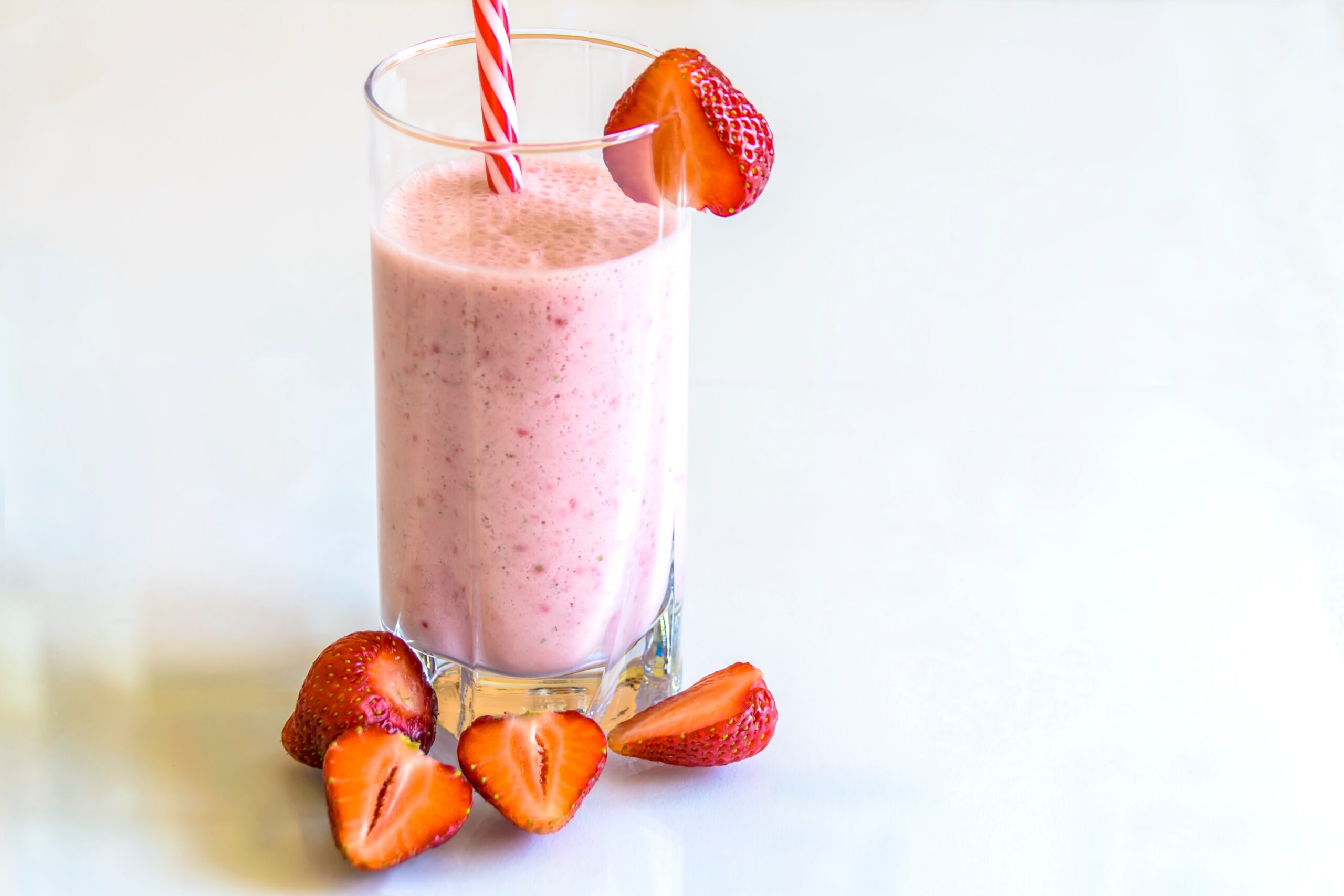 Strawberry smoothie in a glass with a straw