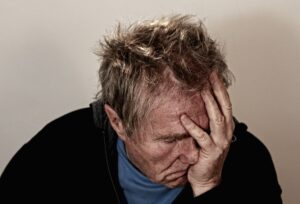 A man with his head in his hands very stressed out.